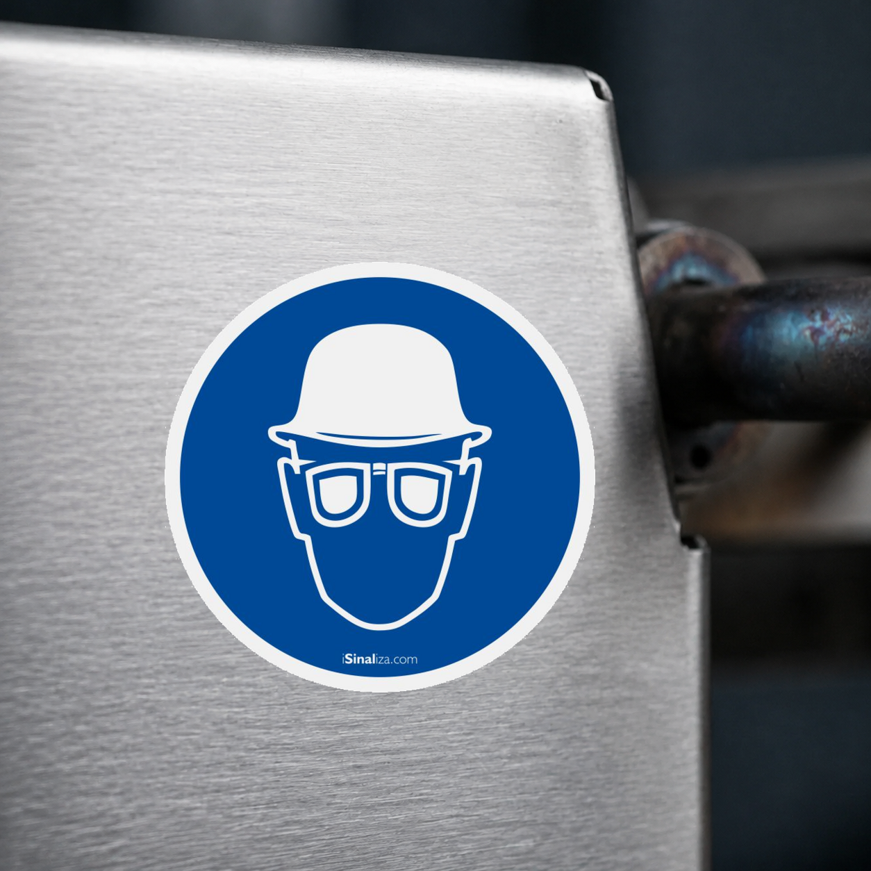 Close-up de etiqueta aplicada em máquina ou equipamento industrial, sem textura e com borda original preservada (até 8 × 8 cm) - Etiqueta de Segurança "Obrigatório Uso de Capacete e Protetor Ocular" - (Embalagem com 10 unidades)