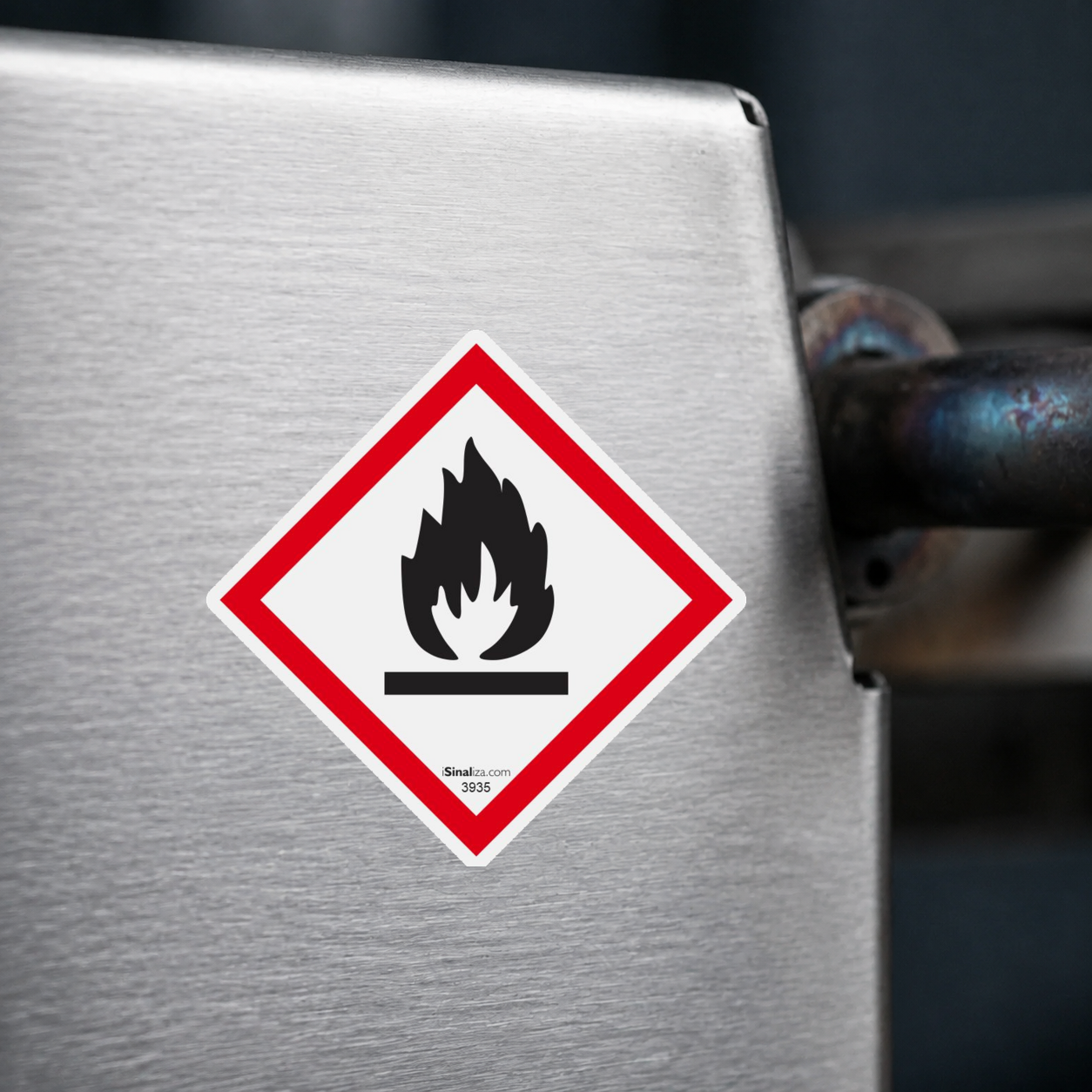 Close-up de etiqueta aplicada em máquina ou equipamento industrial, sem textura e com borda original preservada (até 8 × 8 cm) - Etiqueta de Segurança GHS "Inflamável" - (Embalagem com 10 unidades)