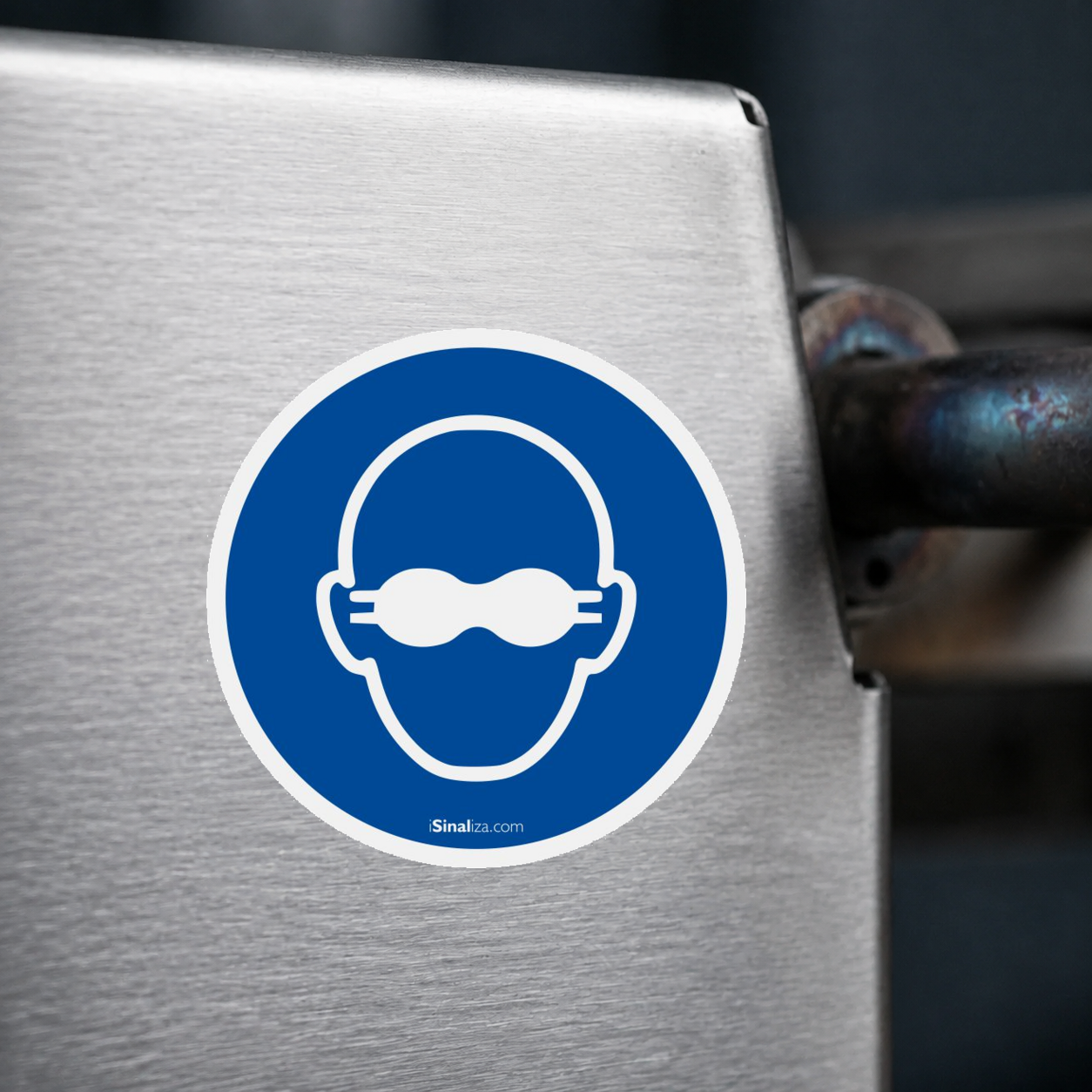 Close-up de etiqueta aplicada em máquina ou equipamento industrial, sem textura e com borda original preservada (até 8 × 8 cm) - Etiqueta de Segurança "Obrigatório Uso de Proteção Ocular" - (Embalagem com 10 unidades)