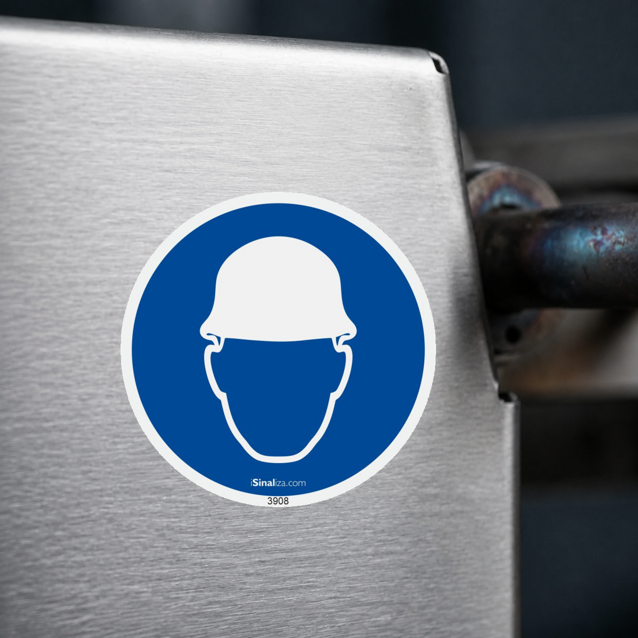 Close-up de etiqueta aplicada em máquina ou equipamento industrial, sem textura e com borda original preservada (até 8 × 8 cm) - Etiqueta de Segurança "Obrigatório Uso de Capacete" - (Embalagem com 10 unidades)