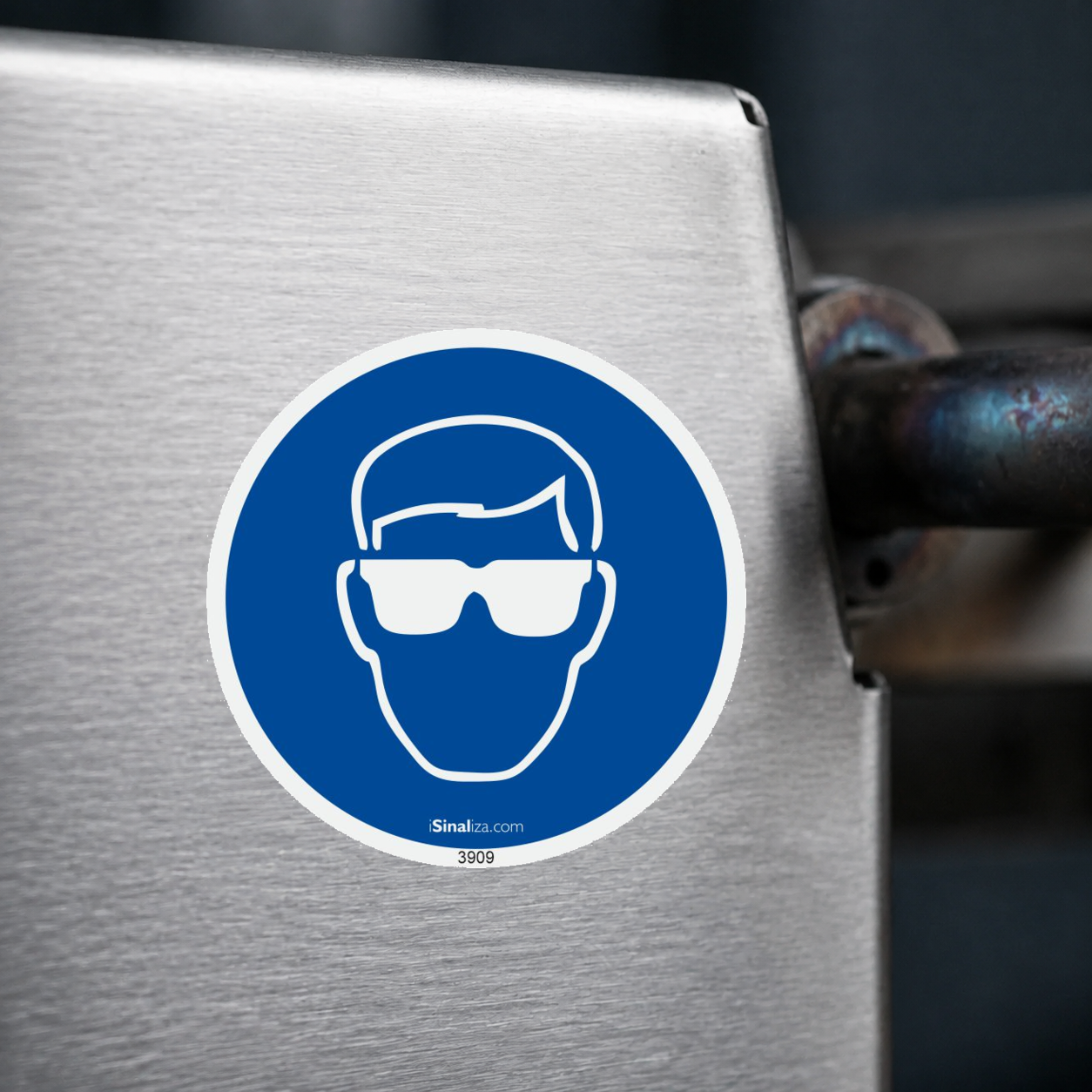 Close-up de etiqueta aplicada em máquina ou equipamento industrial, sem textura e com borda original preservada (até 8 × 8 cm) - Etiqueta de Segurança "Obrigatório Uso de Proteção Ocular" - (Embalagem com 10 unidades)