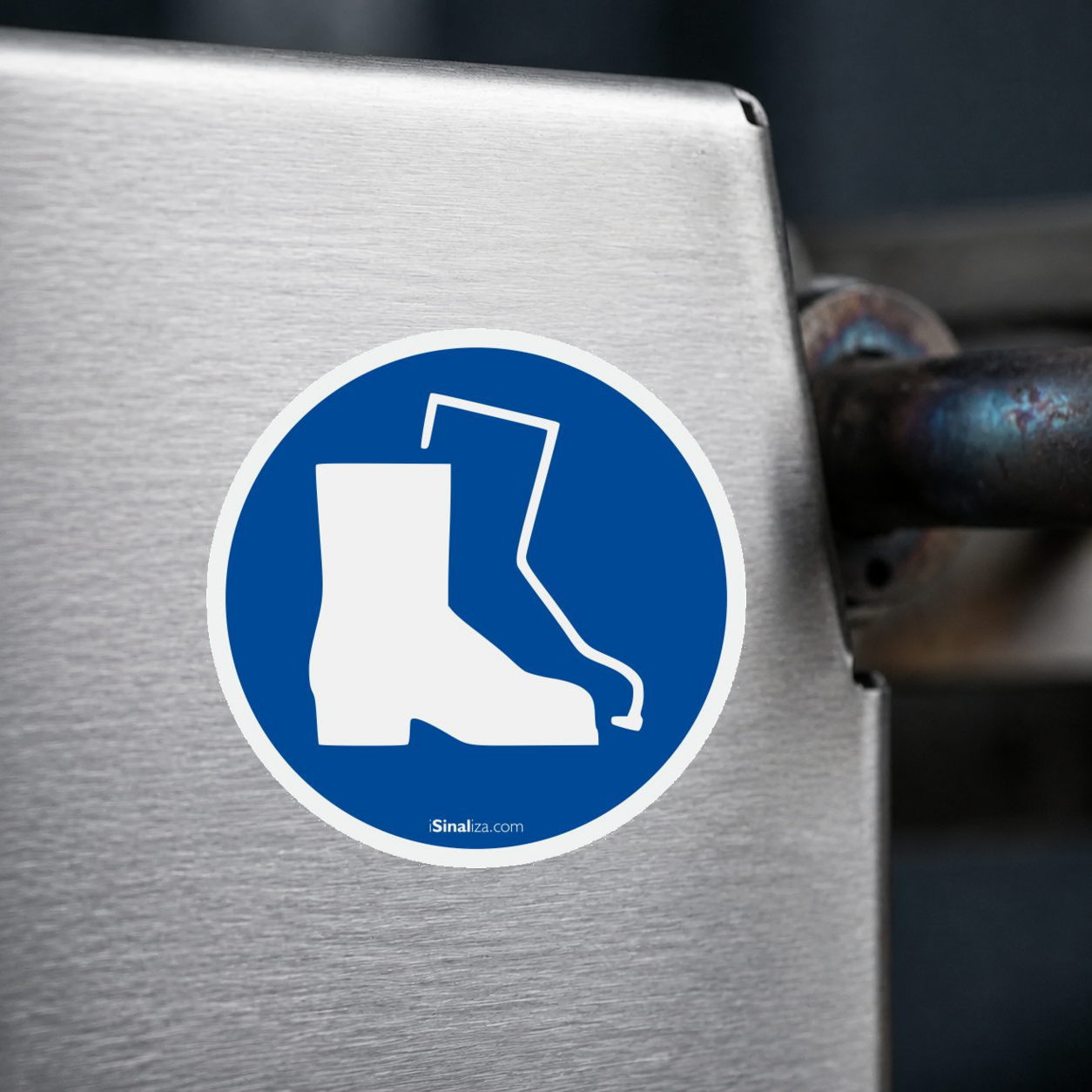 Close-up de etiqueta aplicada em máquina ou equipamento industrial, sem textura e com borda original preservada (até 8 × 8 cm) - Etiqueta de Segurança "Obrigatório Usar Proteção nos Pés" - (Embalagem com 10 unidades)